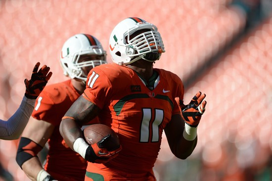 Defensive lineman David Gilbert #11 and The University of Miami Hurricanes plays in a game against the Virginia Cavaliers at Sun Life Stadium on...