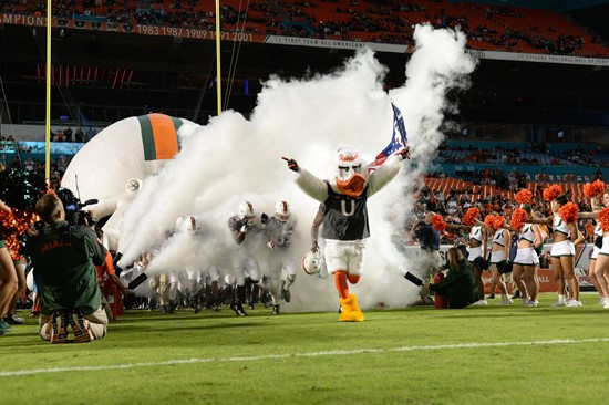 Sebastian the Ibis leads the University of Miami Hurricanes through a tunnel of smoke in a game against The Pittsburgh Panthers at Sun Life Stadium on...