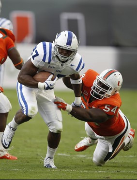 Miami defensive lineman Micanor Regis (54) pressures Duke running back Jay Hollingsworth. (AP Photo/Lynne Sladky)