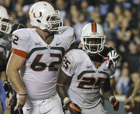 Miami's Shane McDermott (62) and Dallas Crawford (25) celebrate Crawford's game winning touchdown against North Carolina during the second half of an...
