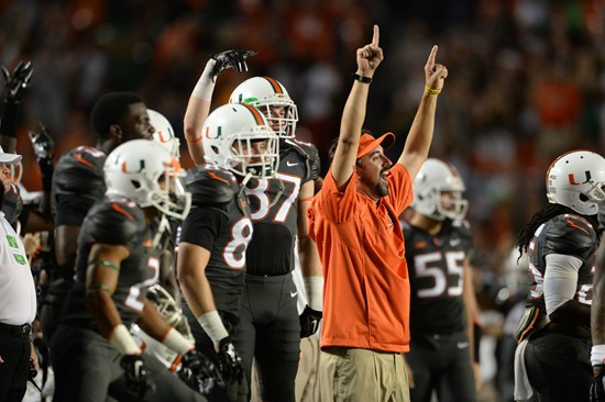 Assistant coaches signal a touchdown on the sidelines in a game against the Duke Blue Devils at Sun Life Stadium on September 27, 2014. Photo by...