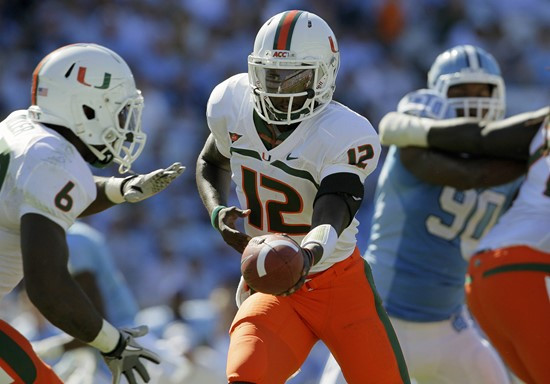 Miami quarterback Jacory Harris (12) hands off to Lamar Miller (6) during the second half against North Carolina. (AP Photo/Gerry Broome)