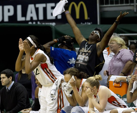 Fans and Miami players Sylvia Brown (34), Shawnice Wilson, center, and Stefanie Yderstrom, right, react after one of their teammates missed a shot...