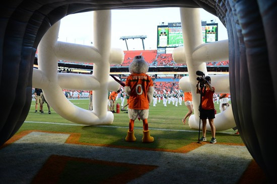 Sebastian the Ibis leads the University of Miami Hurricanes through a tunnel of smoke in a game against the Savannah State Tigers at Sun Life Stadium...