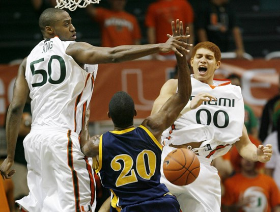 Miami's Anthony King, left, and Jimmy Graham, right, block North Carolina A&T's Cyrus McGowan during first half of a college basketball game at the...