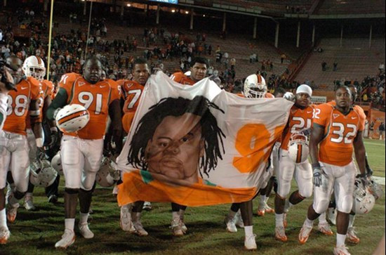 University of Miami teammates carry a Bryan Pata banner that was displayed in the west end zone in honor of the University of Miami standout defensive...