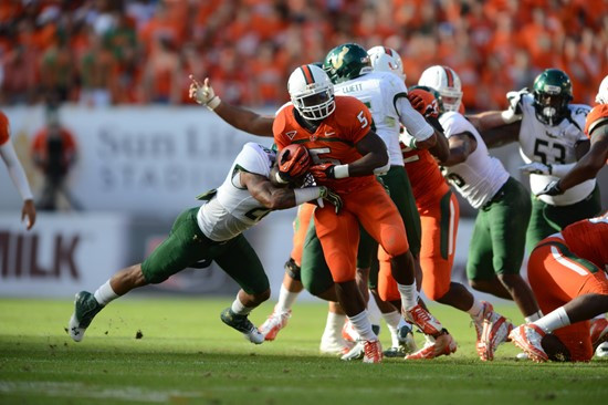 University of Miami Hurricanes running back Mike James #5 carries the ball against the University of South Florida Bulls at Sun Life Stadium on...