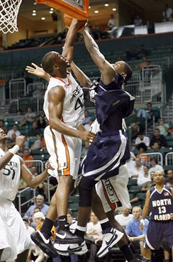 Raymond Hicks, left, blocks the shot of North Florida center James Grimball, right, during the first half of a college basketball game in Miami on...