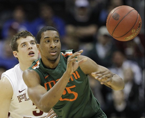 Miami guard Garrius Adams (25) passes the ball ahead of Florida State guard Luke Loucks (3) during the first half of an NCAA college basketball game...