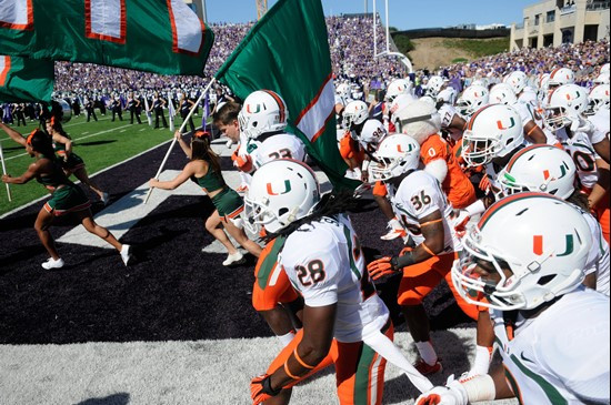 UM team running onto the field at Manhattan, Kan.