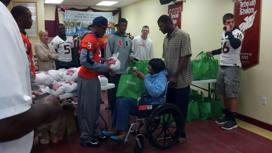 Seven football players and other staff delivered 48 turkey dinners to the Greater Mercy Missionary Baptist Church in Overtown.