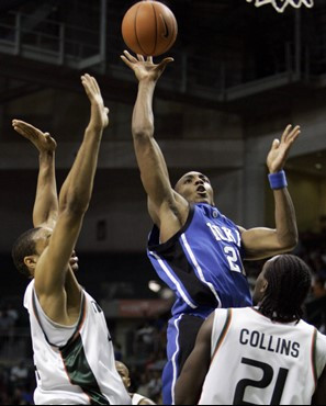 Duke's DeMarcus Nelson, center, shoots to the basket as Miami's Keaton Copeland, left, and Dwayne Collins (21) defend in the first half of a...