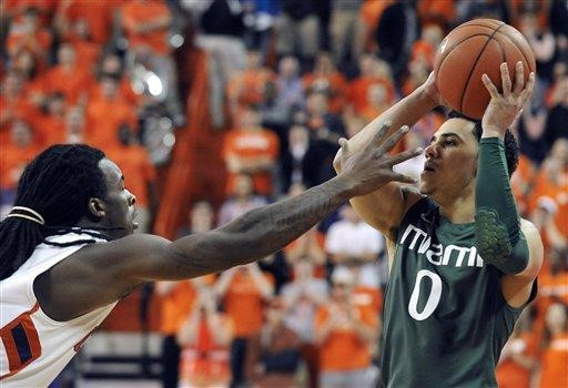 Miami's Shane Larkin (0) looks to pass as Clemson's Rod Hall defends in the first half of an NCAA college basketball game, Sunday, Feb. 17, 2013, in...