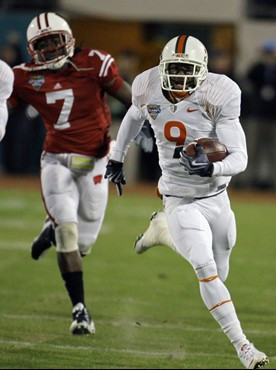 Miami's Sam Shields (9) runs past Wisconsin cornerback Aaron Henry (7) on an 86-yard kickoff return during the first half of the Champs Sports Bowl...