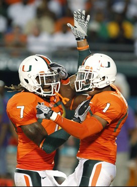 Miami defensive backs Vaughn Telemaque (7) and Brandon Harris (1) celebrate a tackle during the first half of an NCAA college football game against...