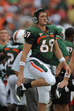 University of Miami Hurricanes long snapper/quarterback Jake Byrne #69 calls in a play from the sideline in a game against the Deamon Deacons of Wake...