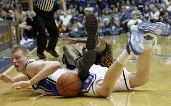 Duke's Kyle Singler, left, and Miami's Anthony King fall to the floor during the first half of a college basketball game in Durham, N.C., Saturday,...