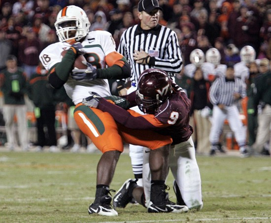 Dedrick Epps tries to break the tackle of Virginia Tech linebacker Vince Hall during the second half. (AP Photo/Steve Helber)