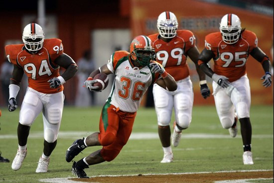 Florida A&M runningback Anthony Edwards (36) runs for yardage against Miami defensive end Eric Moncur (94) defensive tackle Kareem Brown (99) and...