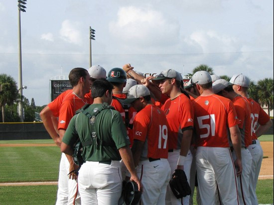 Orange team huddles prior to game one of the Orange-Green World Series on Monday.