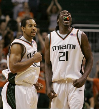 Miami guard Anthony Harris, left, and forward Dwayne Collins celebrate during the final seconds of the second half of college basketball play against...