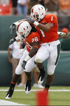 Miami's Thearon Collier (28) celebrates with teammate Brandon Harris after returning a punt for a touchdown against Virginia during the first quarter...
