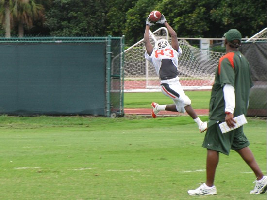 Kendal Thompkins goes up for a ball during a wide receiver drill as Coach McDonald looks on.