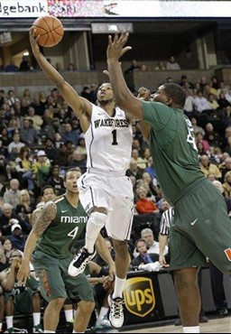 Wake Forest's Madison Jones (1) drives past Miami's Reggie Johnson (42) and Trey McKinney Jones (4) during the first half of an NCAA college...