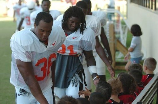 University of Miami Linebackers Kylan Robinson #36 and Sean Spence #31 great the Kendall Hammocks Warriors Pee Wee football team after they worked out...