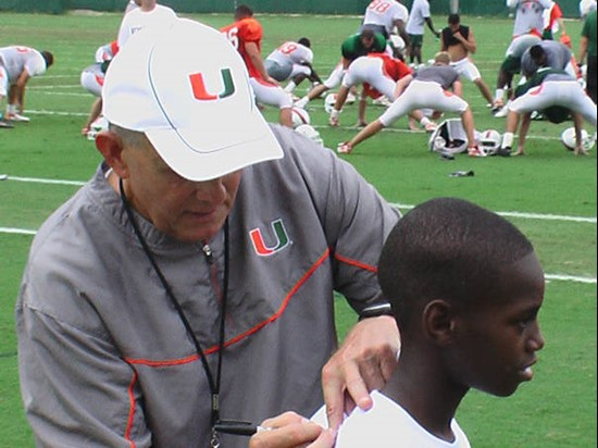 Head Coach Larry Coker autographs a student's t-shirt.