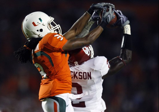 Travis Benjamin grapples for a pass with Oklahoma defensive back Brian Jackson.