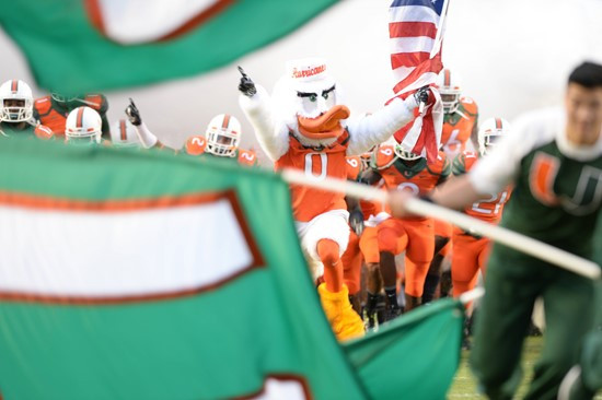 Sebastian the Ibis leads the University of Miami Hurricanes onto the field through a tunnel of smoke in a game against the Florida A&M Rattlers at Sun...