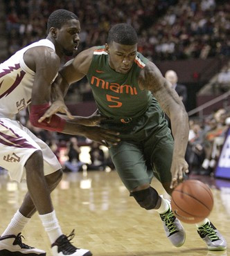 Miami's Dequan Jones, right, tries to get around the defense of Florida State's Okaro White in the first half of an NCAA college basketball game on...