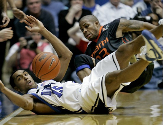 Duke's Gerald Henderson, left, and Miami's Jack McClinton battle for a loose ball during the first half of a college basketball game in Durham, N.C.,...