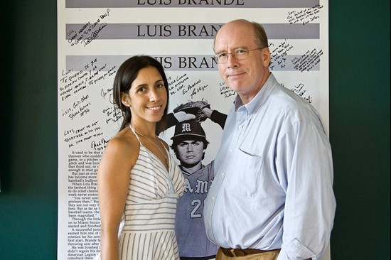 Event organizers Magda Gonzalez & Rick Remmert pose in front of the Luis Brande poster.