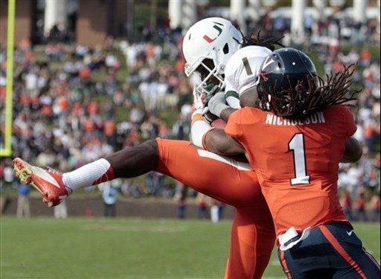 Miami wide receiver Allen Hurns (1) hauls in a pass in front of Virginia cornerback Demetrious Nicholson (1) during the first half of an NCAA college...