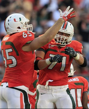 Miami offensive linesman Brandon Linder (65) and defensive lineman Anthony Chickillo (71) celebrate after Chickillo recovered a fumble during second...