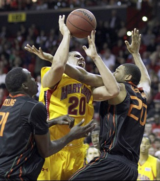 Maryland's Jordan Williams (20) is fouled by Miami's Cyrus McGowan (20) as teammate Dwayne Collins (21) looks on during the first half. (AP Photo/Rob...