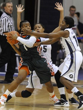 Miami guard Riquana Williams (1) looks for a teammate as Georgetown defenders Adria Crawfore (5) and Morgan Williams, right, put the pressure on...
