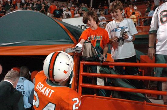 University of Miami Hurricanes defensive back Chavez Grant #24 gives his gloves to fans after a game against the Florida International University...