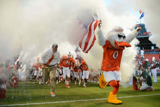 Sebastian the Ibis leads the University of Miami Hurricanes through a tunnel of smoke in a game against the Savannah State Tigers at Sun Life Stadium...