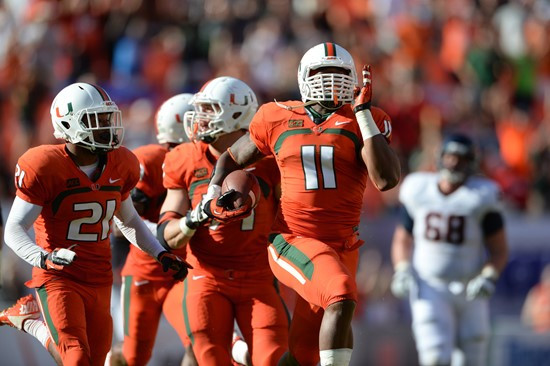 Defensive lineman David Gilbert #11 and The University of Miami Hurricanes plays in a game against the Virginia Cavaliers at Sun Life Stadium on...