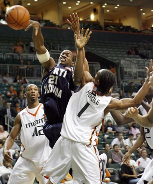 North Florida center Dwayne Collins (21) is fouled by Miami guard Lance Huedle (1) defending, in the second half of their college basketball game in...