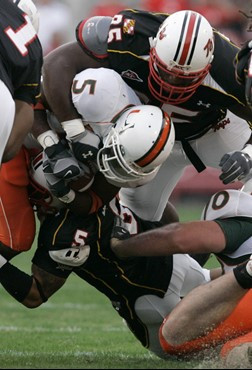 Miami running back Javarris James (5) is tackled by Maryland's Isaiah Gardner, bottom, and Conrad Bolston, top, during the first half of their...