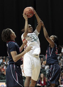 Miami's Morgan Stroman (32) is fouled by Ole Miss' Whitney Hameth, right, as Kenyotta Jenkins, left, defends in the first half. (AP Photo/Alan Diaz)