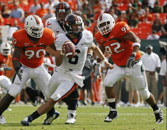 Virginia quarterback Marc Verica (6) scrambles under pressure from Miami's Stephen Wesley (90) and Josh Holmes (92) during the second quarter of an...