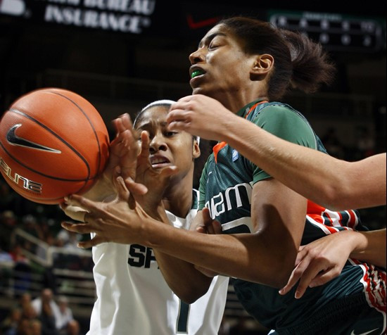 Miami's Morgan Stroman, right, and Michigan State's Jasmine Thomas battle for a rebound during the first half. (AP Photo/Al Goldis)