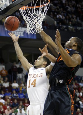 Texas guard D.J. Augustin takes a shot as Miami forward Raymond Hicks defends in the first half. (AP Photo/Sue Ogrocki)