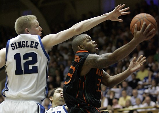 Duke's Kyle Singler (12) defends as Miami's Jack McClinton drives to the basket during the second half of a college basketball game in Durham, N.C.,...