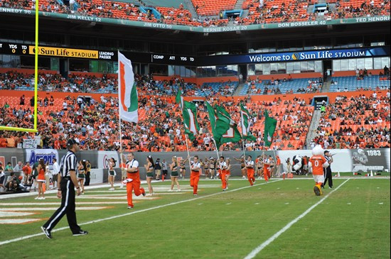 University of Miami Hurricanes fans celebrate after the Canes score a touchdown in a game against the Boston College Eagles at Sun Life Stadium on...